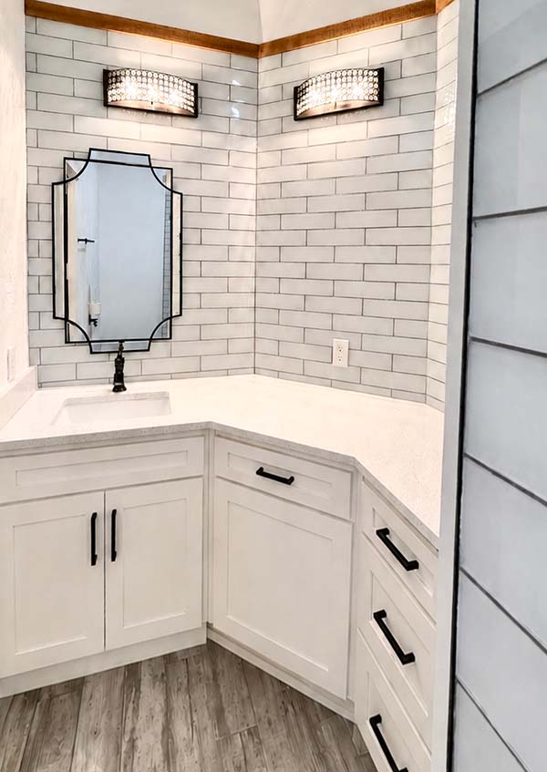 Painted white bathroom vanity cabinets with black hardware and subway tile surround in North Dallas