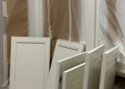 cabinet painting doors drying in paint booth smooth white finish raised panel