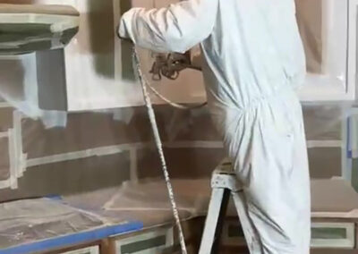 cabinet painting spray application technician full protective suit kitchen in progress masking