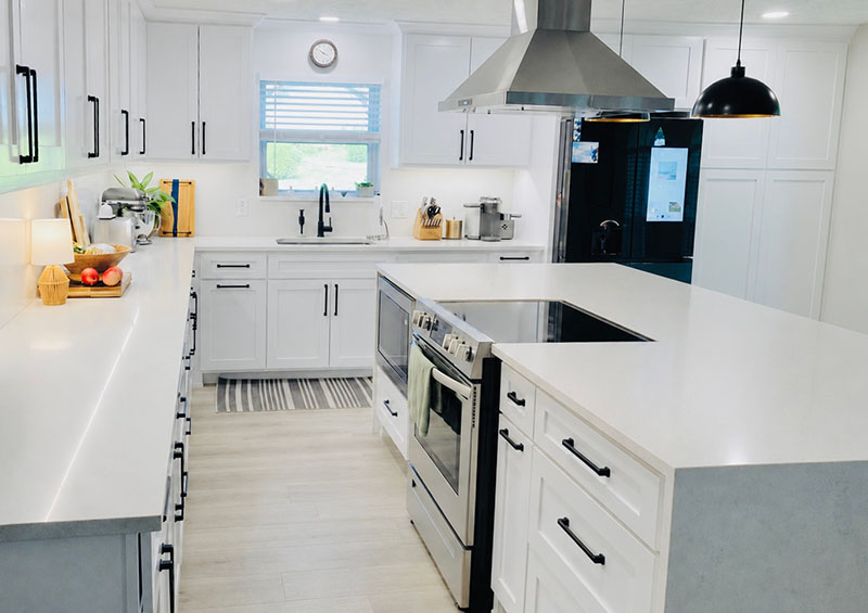 Full kitchen with freshly painted white shaker cabinets, black hardware, and white quartz countertops in North Dallas