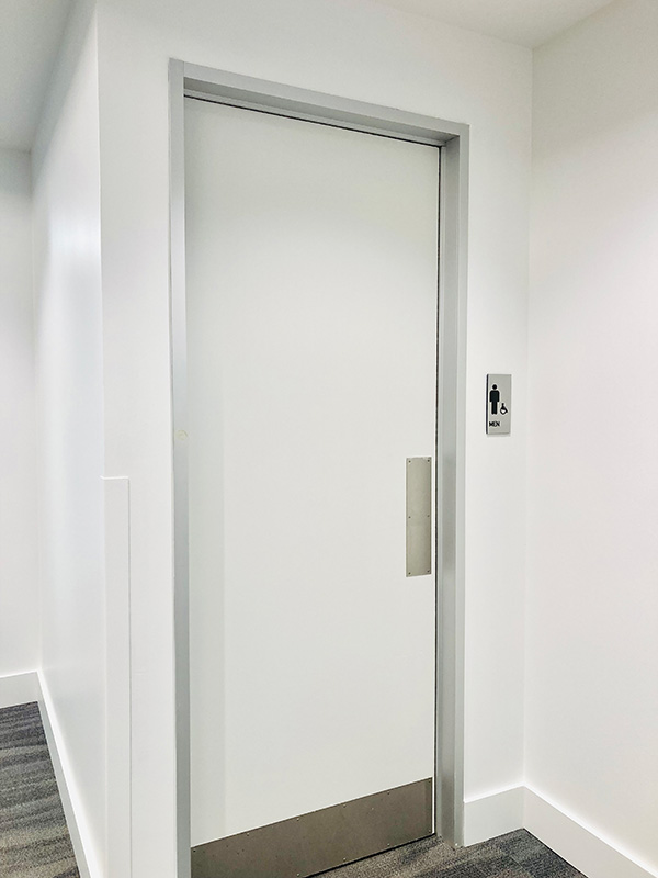 Painted white interior commercial door with aluminum frame in North Dallas office building
