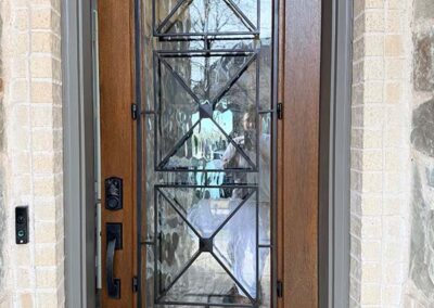 door painting wood front entry door iron decorative glass insert stone surround close up