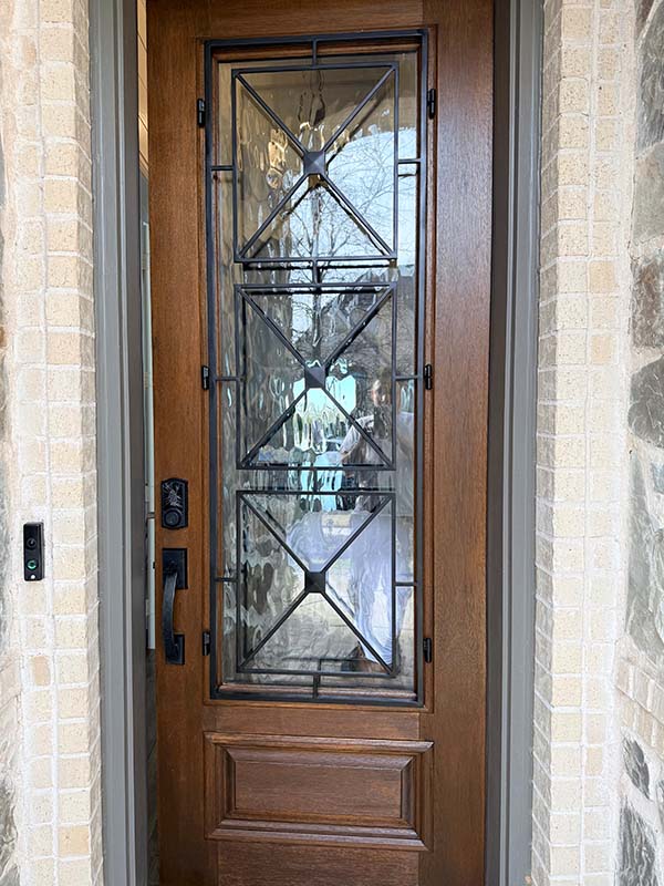 door painting wood front entry door iron decorative glass insert stone surround close up