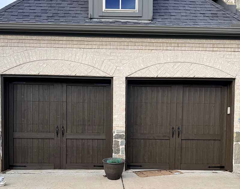 Stained dark walnut double garage doors on brick home in North Dallas