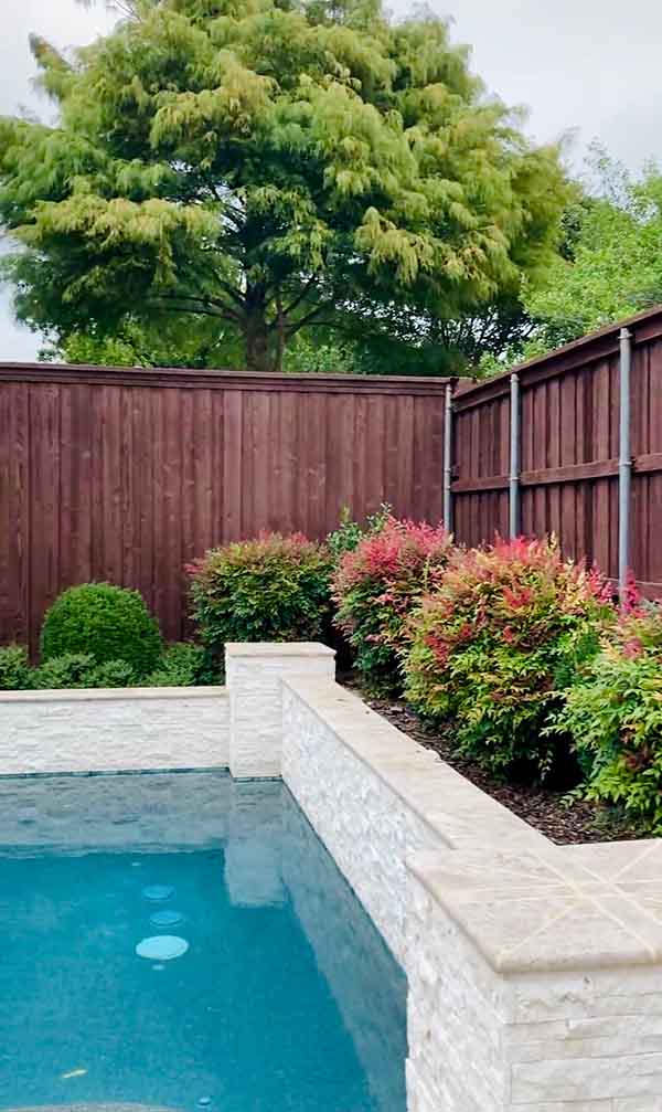 Fence Staining Services – North Dallas | PPP North Dallas Dark brown stained wood privacy fence next to pool in North Dallas backyard