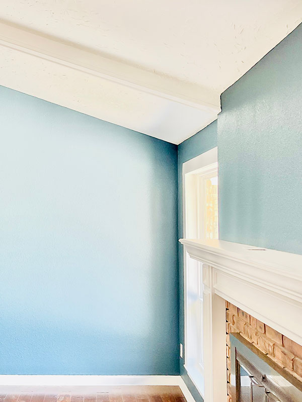 Interior room with freshly painted blue walls, white crown molding, and white fireplace mantel in North Dallas home