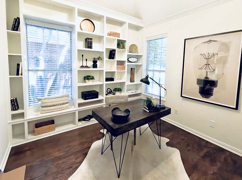 Interior painted home office with white built-in shelving, crown molding, and white walls in North Dallas
