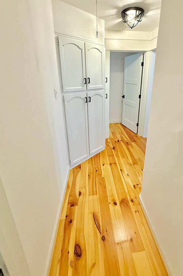 Interior painted white hallway with painted arched cabinet doors and painted interior doors in North Dallas home