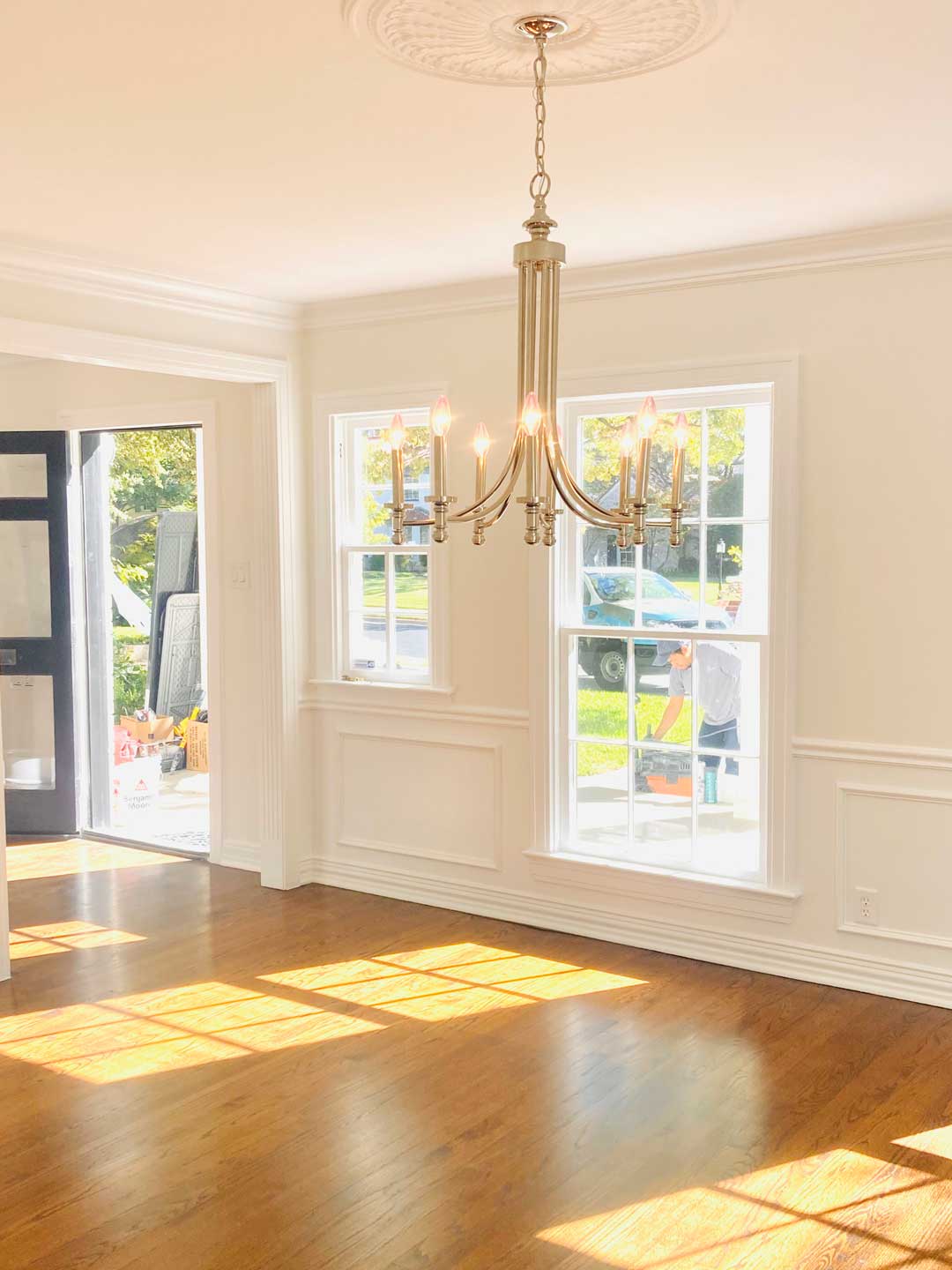 Freshly painted white wainscoting, crown molding, and window trim in North Dallas dining room
