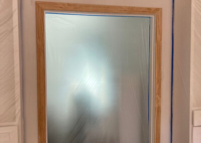 trim painting doorway bare wood trim installed plastic sheeting sealed blue tape surface protection