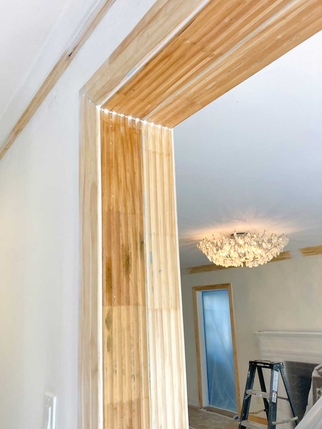 Raw wood doorway casing and crown molding prepped for trim painting in North Dallas home
