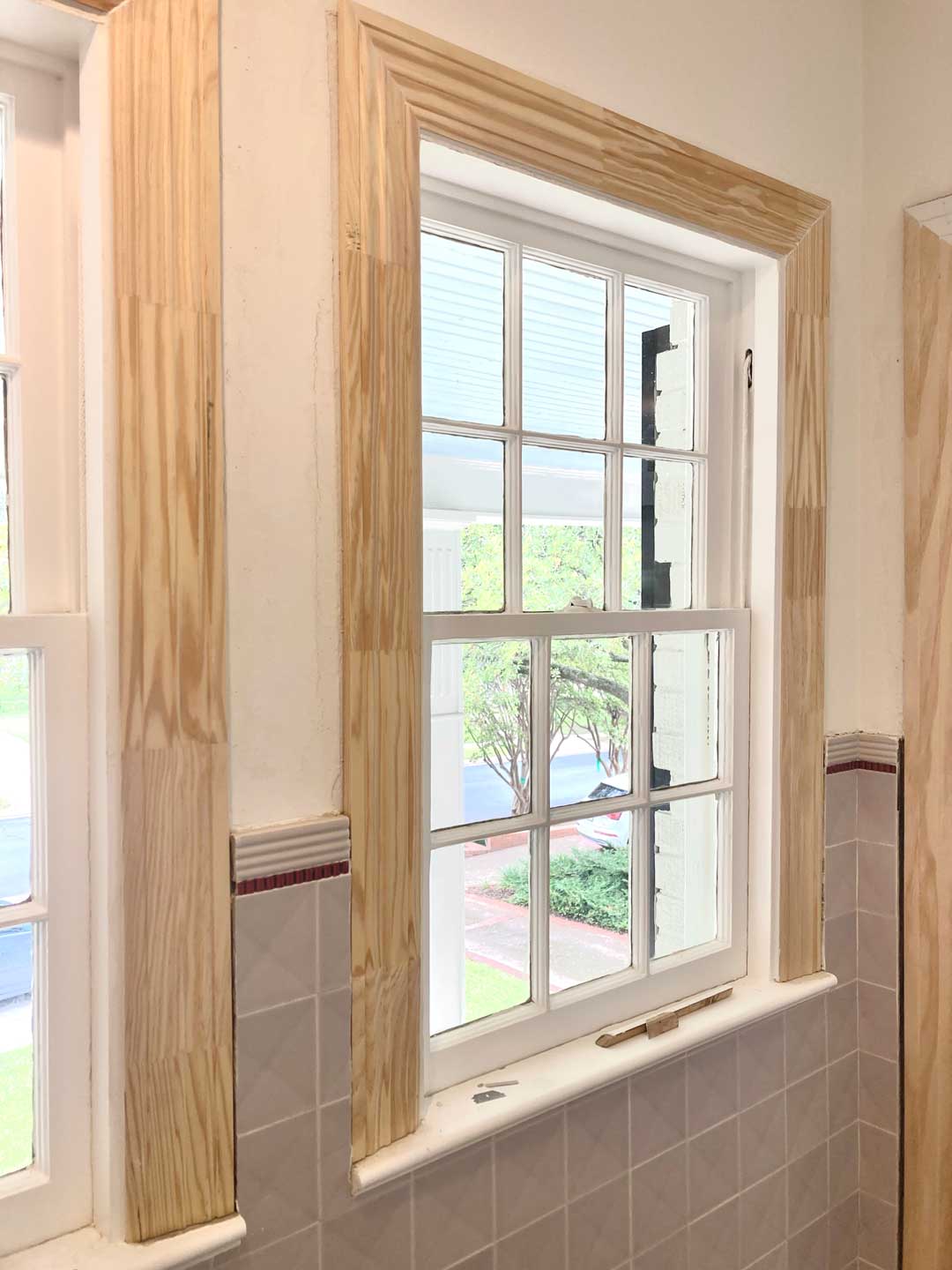 Raw wood window casing prepped for trim painting above tile wainscoting in North Dallas home
