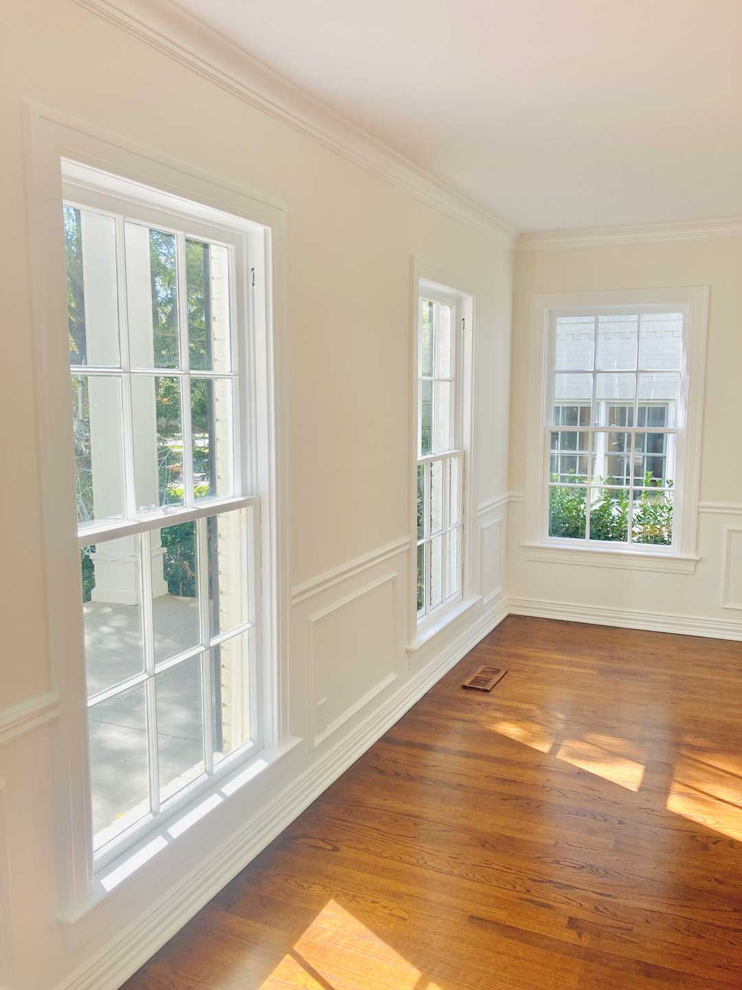 Freshly painted white window trim, wainscoting, and crown molding in North Dallas room