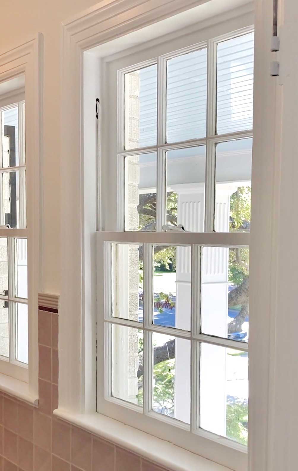 Freshly painted white window casing and trim above tile wainscoting in North Dallas home